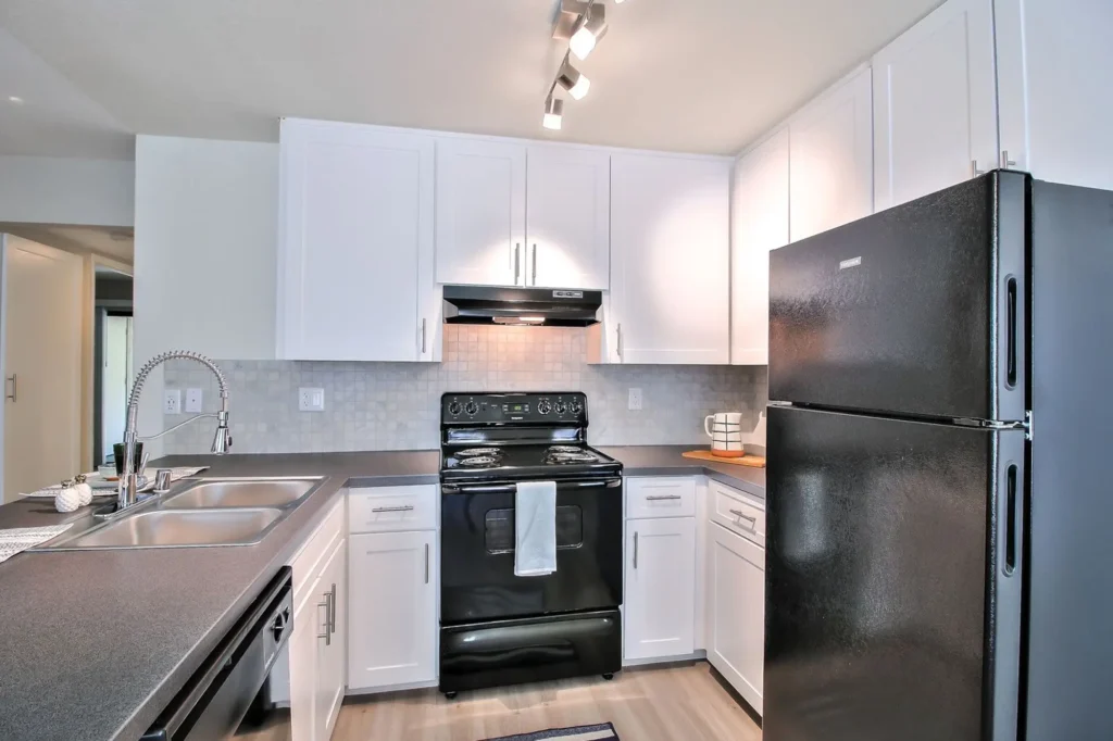 Kitchen with black appliances and tile backsplash