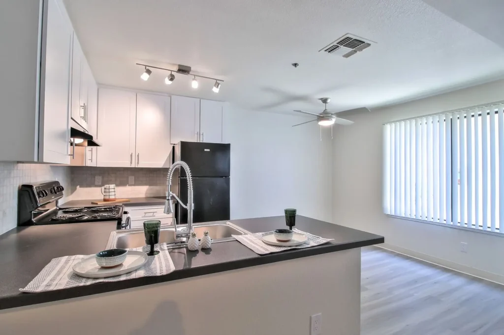 Kitchen with black appliances and tile backsplash